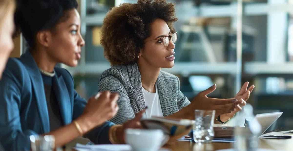four business professionals sitting at a desk and reviewing account plan